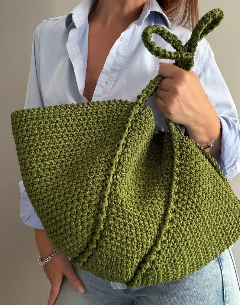 Aura crochet shoulder bag carried by its handle